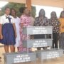 Ms Sowah (fifth from left) presenting the stoves to Mrs Obuo-Nti Photo - Victor A. Buxton
