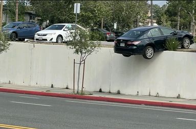 Car gets stuck on wall after parking mishap