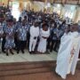• Rev Fr Bernard Kyei (back to the camera) praying for Mr & Mrs Kenneth Azumah (middle) surrounded by the choristers in the new dress