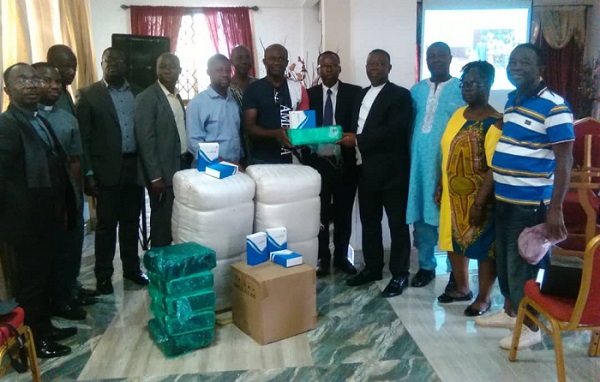 • Pastor Dr. Arloo (fourth from right) receiving the items from Mr. Agbo while some church elders look on