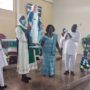 Madam Victoria Kponyoh (standing in the middle) while the Marian statue is raised forthe congregation to see. Standing right is Mr Peter Gagah