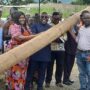 Mr Seth Acheampong ( in suit) with Dr Cecilia Odame and the ECG officials lifting one of the electricity poles