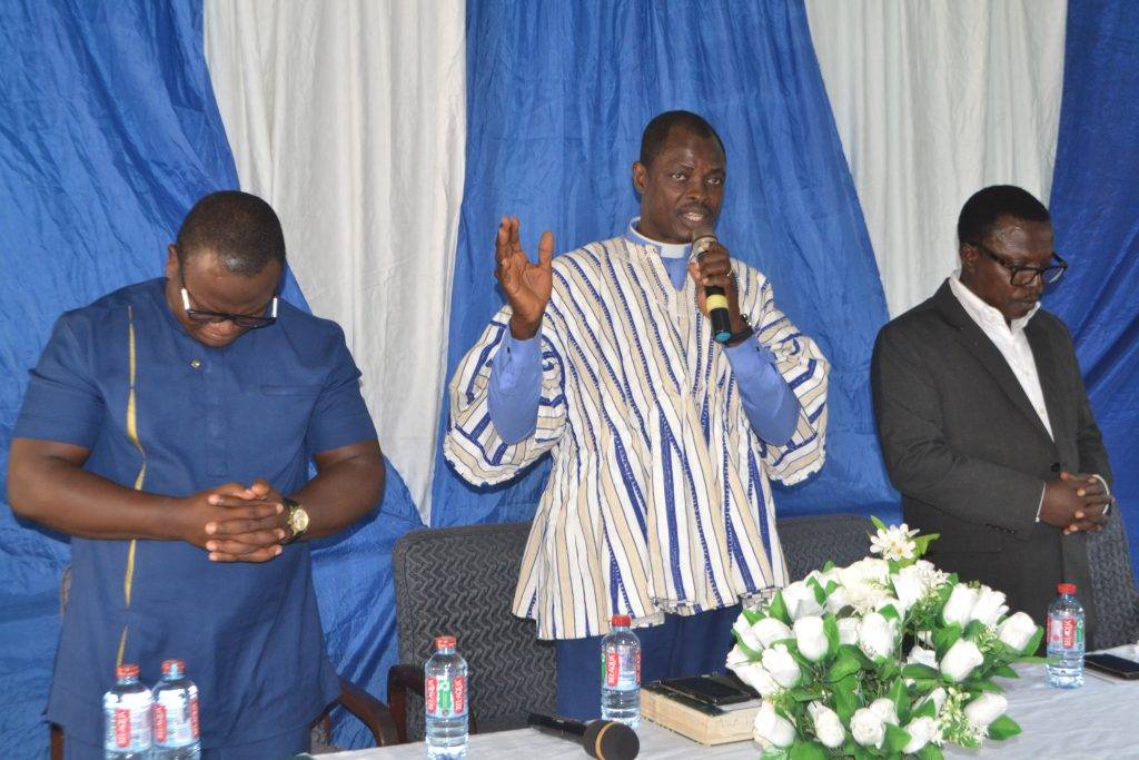 Rev Joseph Oman Ocquaye [middle] praying for the Corporation with him right Mr Adu-Owusu.