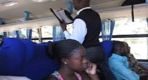 A Ghanaian pastor preaching in a bus